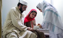 Subhan calms his daughter Afia as she receives injection for cutaneous leishmaniasis lesion at the MEDSF treatment centre in Naseerullah Khan Babar Memorial hospital, Peshawar.